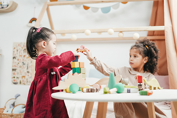 Preschool children paying with blocks.