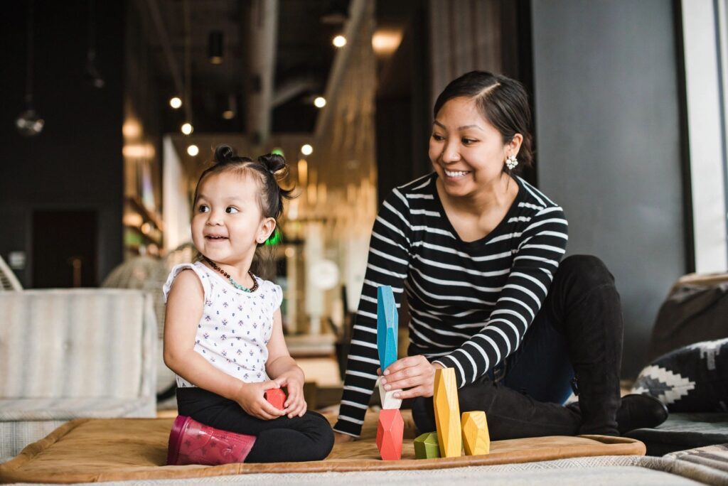 Mother playing blocks with her young child.