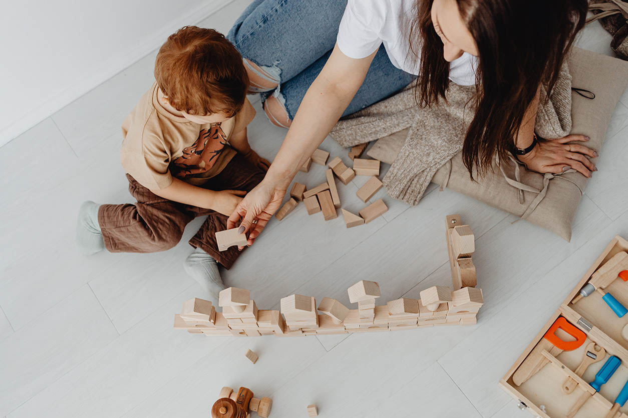 Child and adult building with blocks