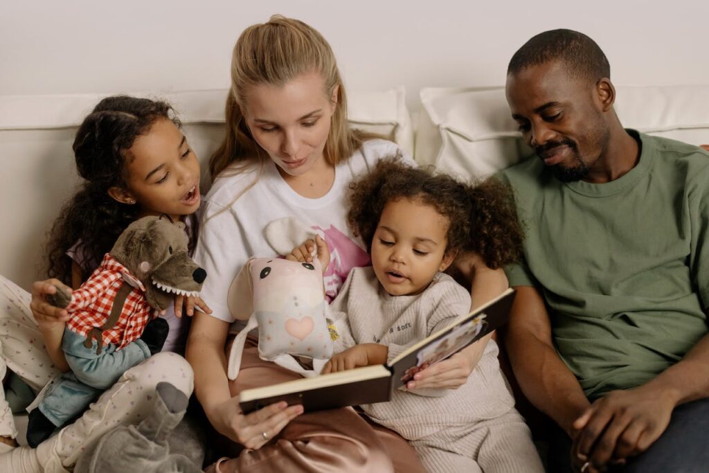 A family with young children reading  book together.