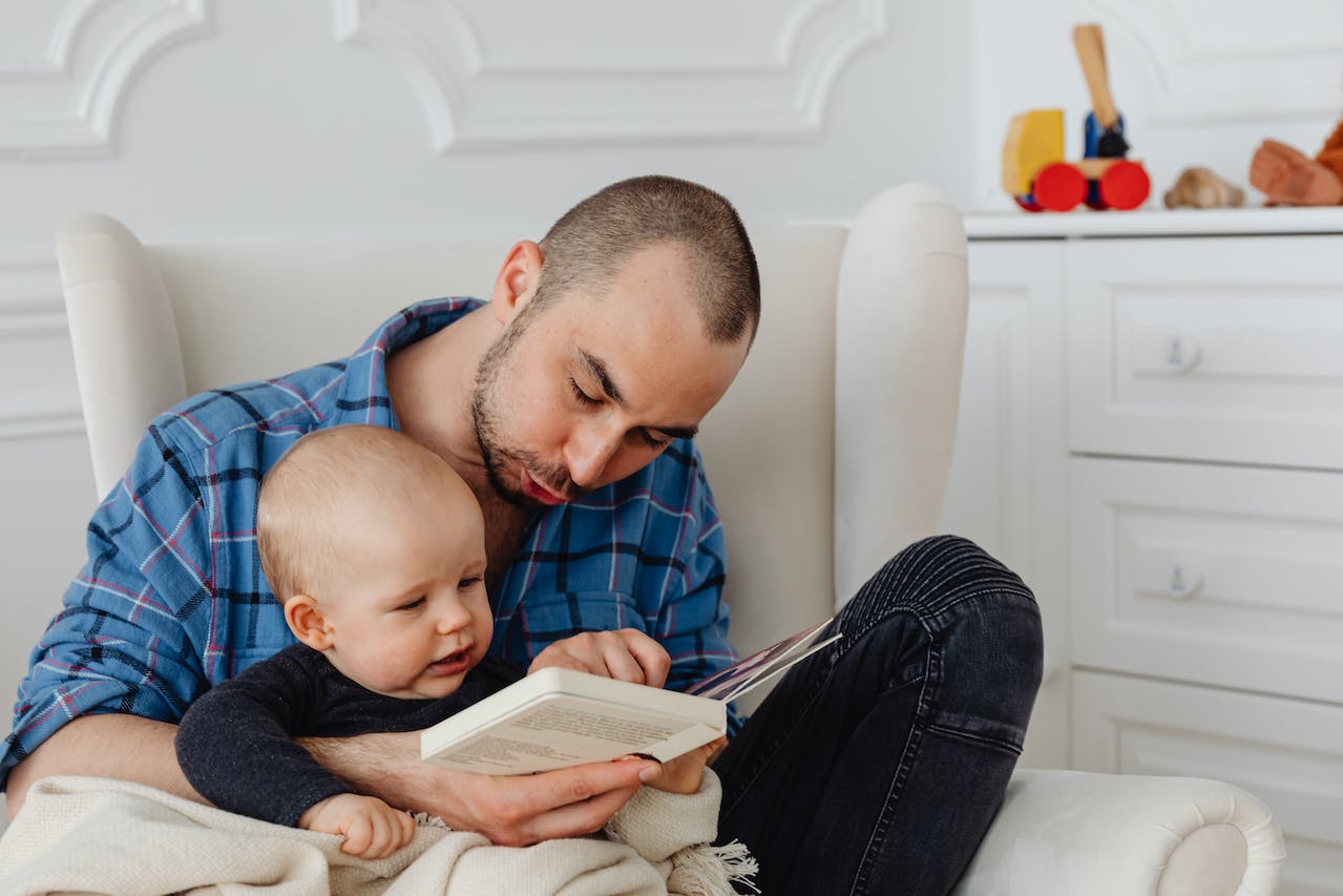 A father reading a book to his baby